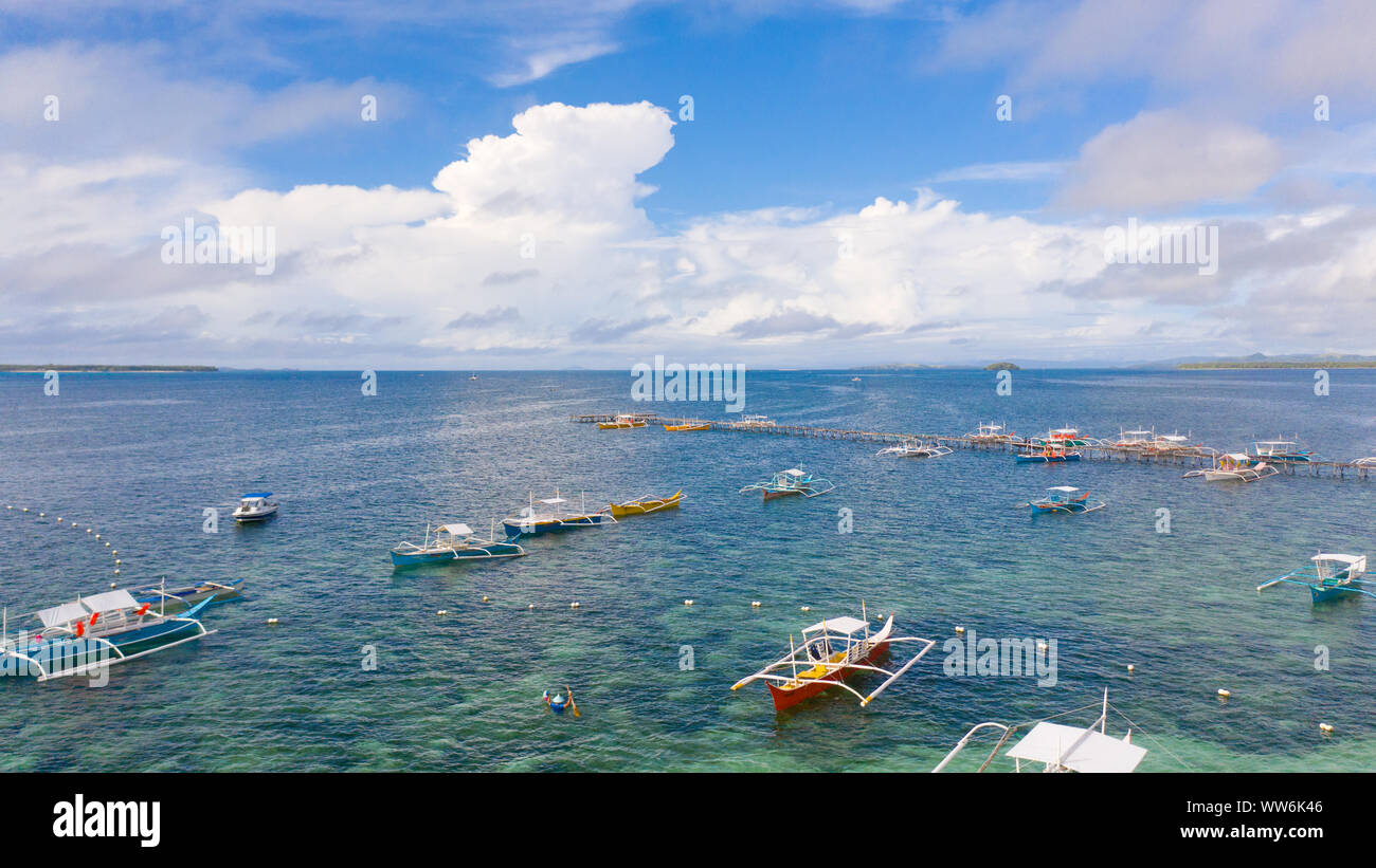 Paesaggio marino con barche e nuvole. Molte imbarcazioni turistiche nella baia durante il giorno. Siargao, Filippine, vista dall'alto. Foto Stock