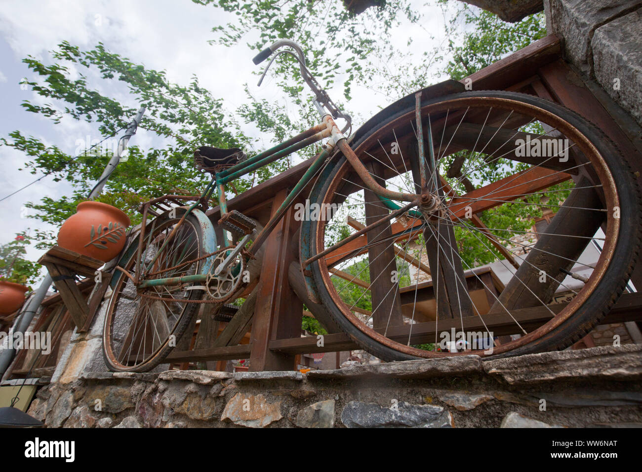 Vecchia bicicletta come di un eye-catcher nella parte anteriore della ringhiera in legno in Grecia Foto Stock