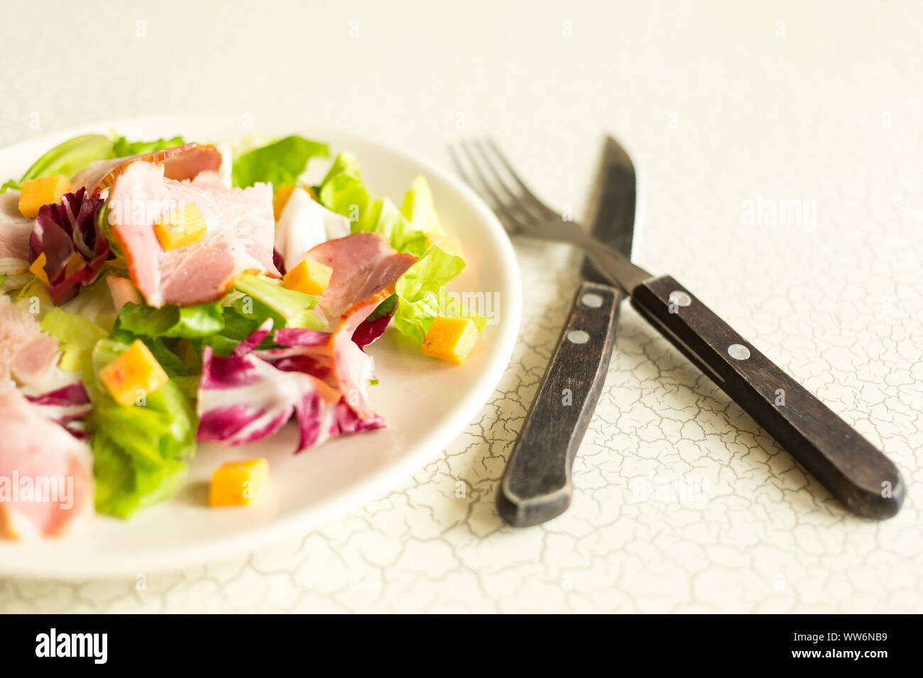 Un piatto di insalata di foglie verdi, prosciutto e formaggio. Posate e un piatto di insalata fresca. Il pranzo. La colazione è intercontinentale presso l'hotel. Foto Stock