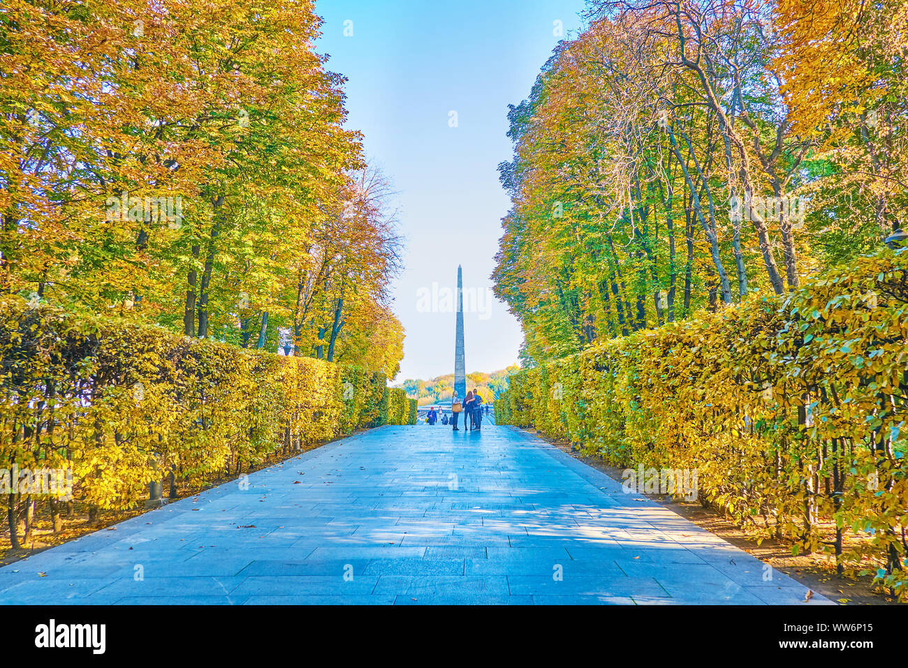 KIEV, UCRAINA - 19 ottobre 2018: il vicolo in autunno Parco della gloria eterna conduce a la tomba del Soldato sconosciuto con alto obelisco di pietra ed eterna F Foto Stock