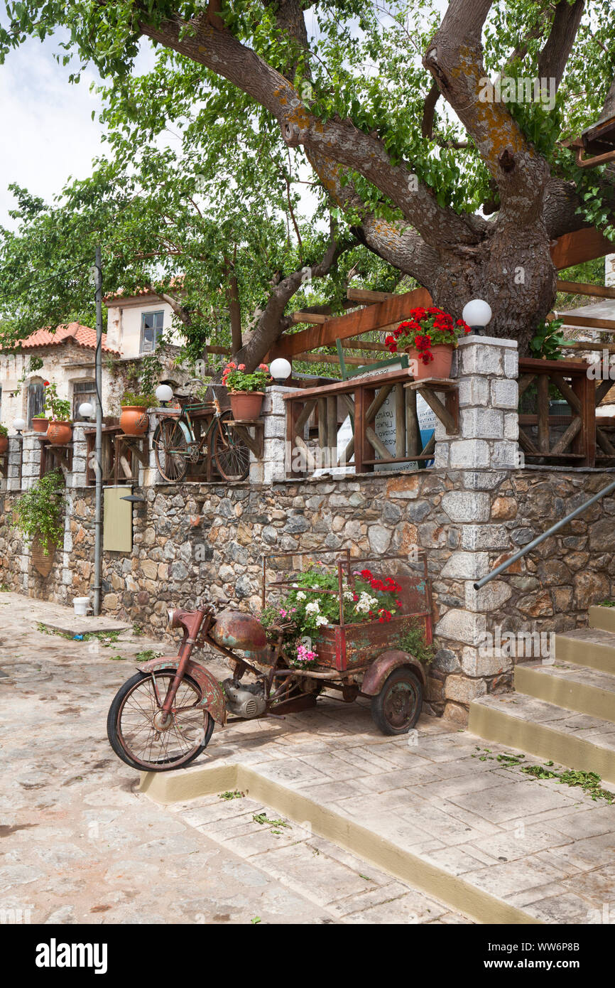 Motociclo arrugginito sotto gli alberi come un eye-catcher in Grecia Foto Stock