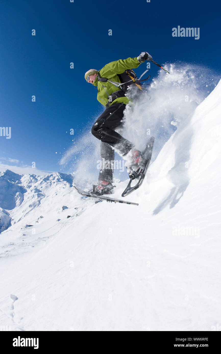 Salto nella neve profonda con le racchette da neve, Kraxntrager, vicino HochfÃ¼gen, Alpi della Zillertal, Tirolo, Austria Foto Stock
