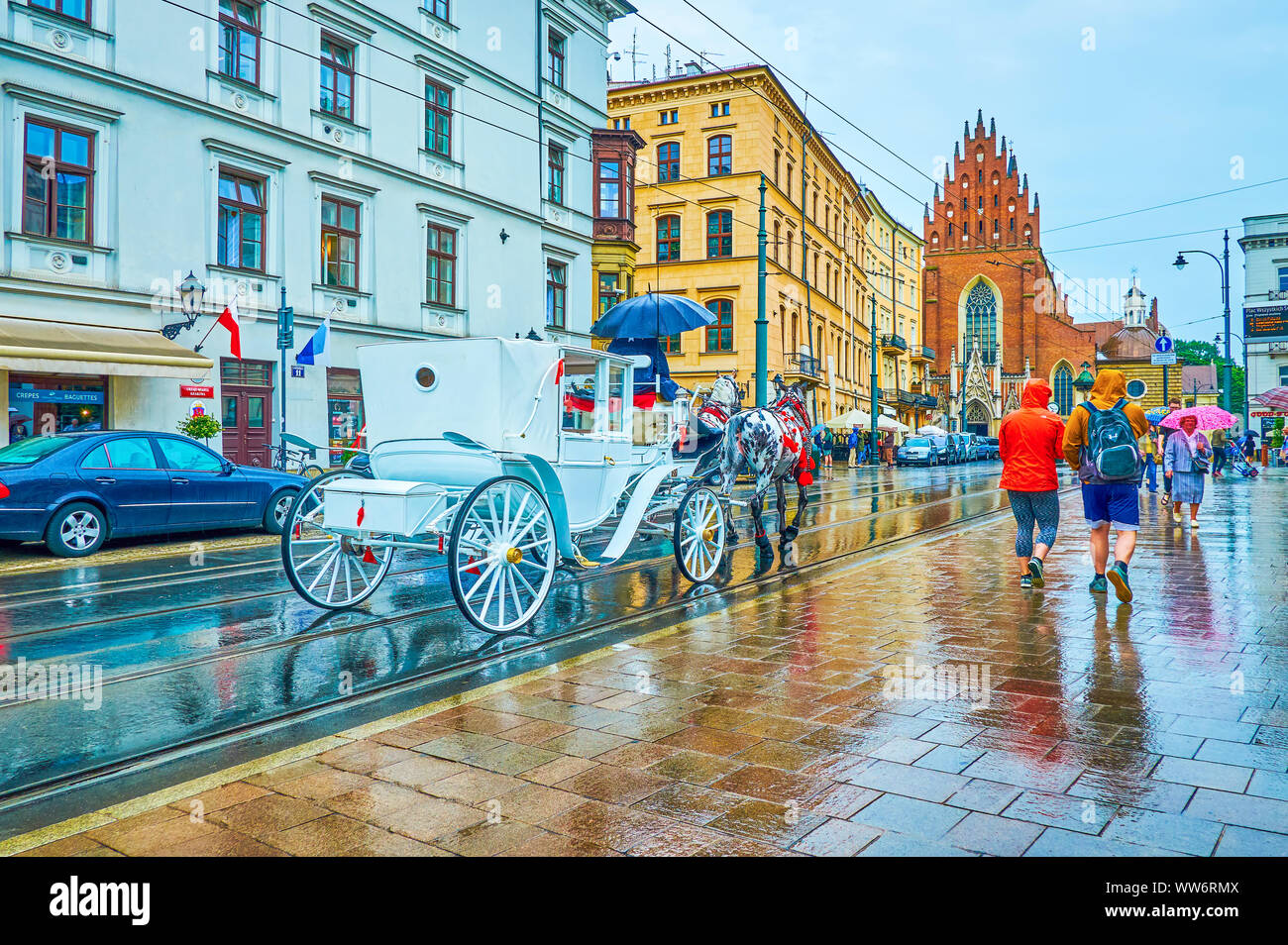 Cracovia in Polonia - Giugno 13, 2018: La scena urbana nella giornata di pioggia con il maneggio carrello lungo tutte le Saint Square, il 13 giugno a Cracovia Foto Stock