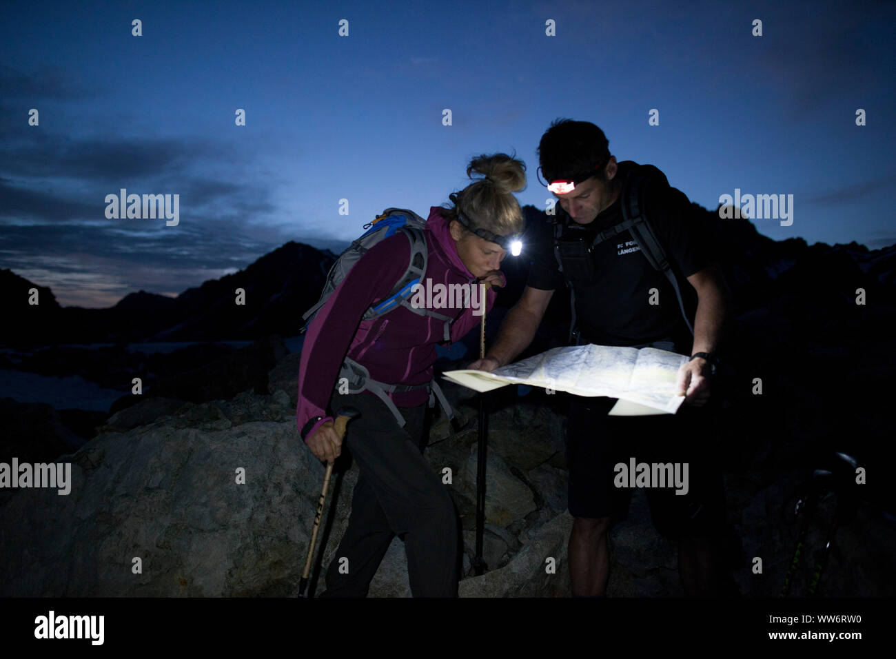 Alpinista su Patteriol la lettura di una mappa di notte, Verwall, Tirolo, Austria Foto Stock