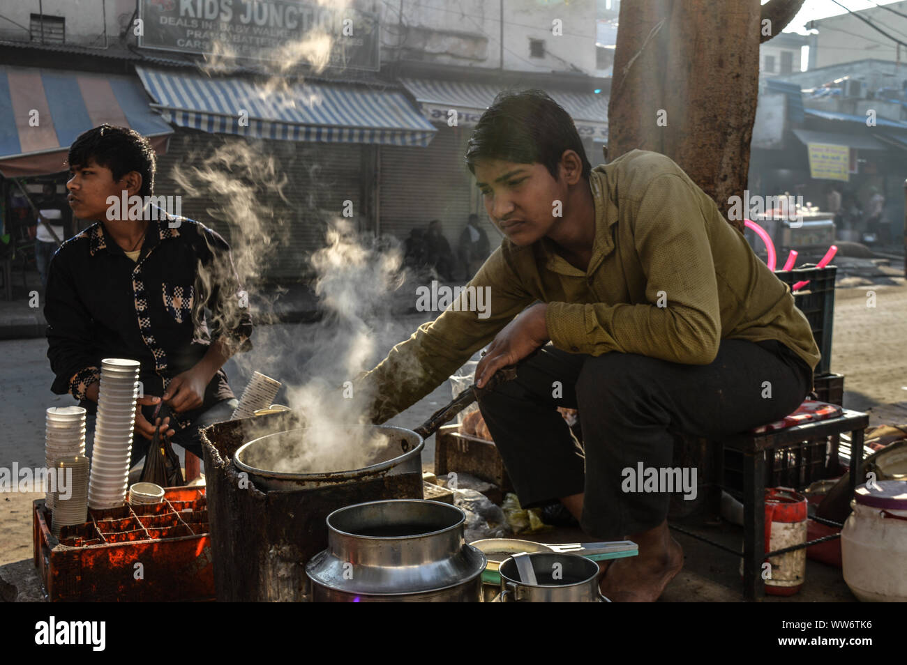 Ragazzo indiano il tè in strada di Chandni Chowk al mattino, fumo Foto Stock