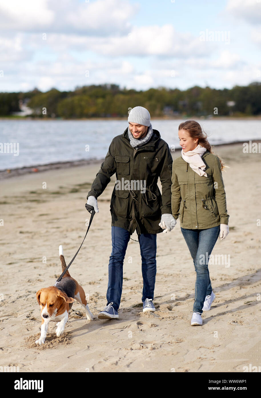 Giovane con cane beagle camminando lungo la spiaggia di autunno Foto Stock