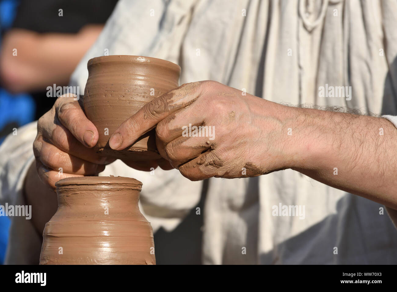 Ceramica ceramista maschio crea un fatto a mano prodotto di creta. Processo di rotazione della ruota di vasai, mani del ceramista. Foto Stock