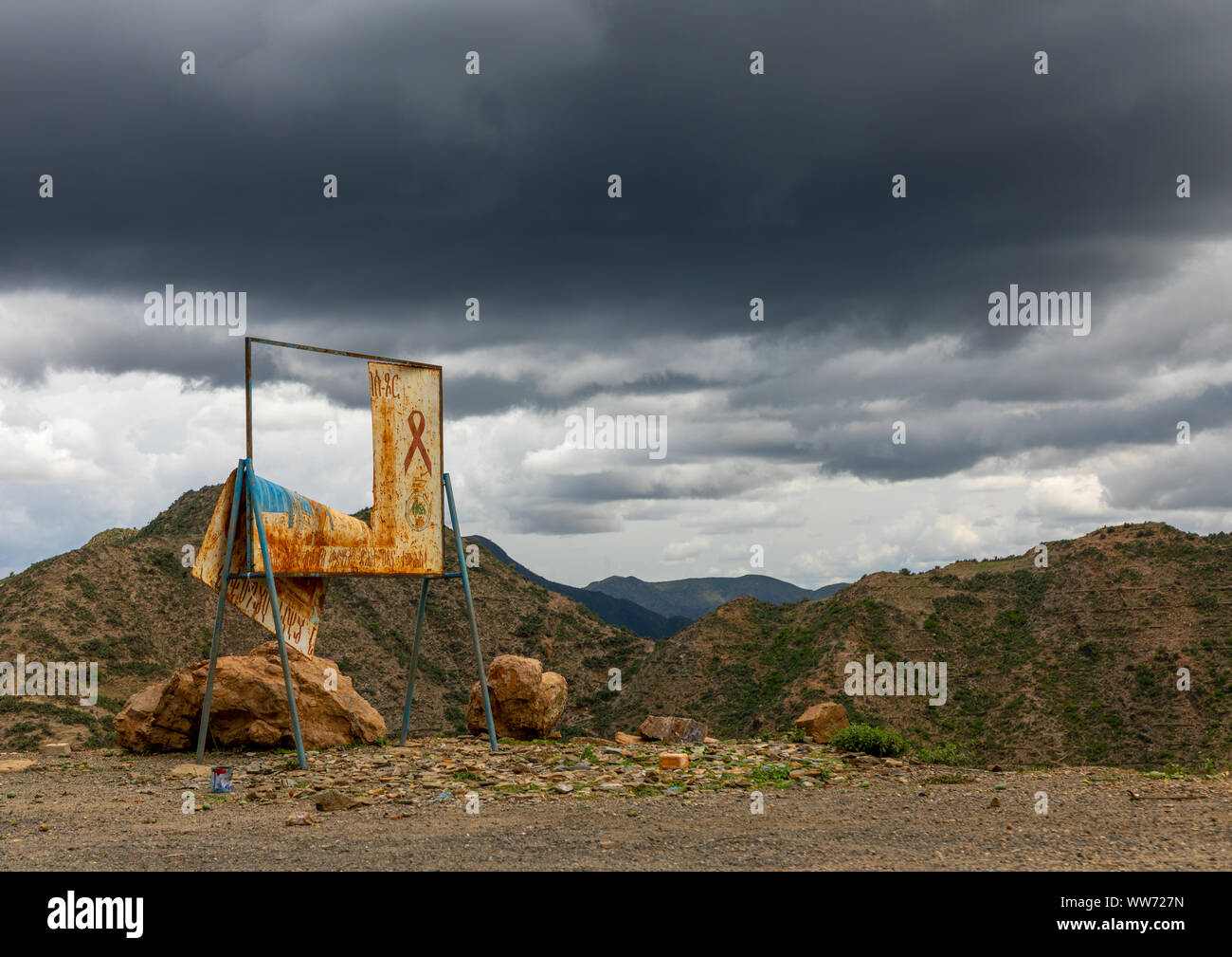 Vecchio hiv billboard contro nuvole temporalesche nelle highlands, regione centrale di Asmara Eritrea Foto Stock