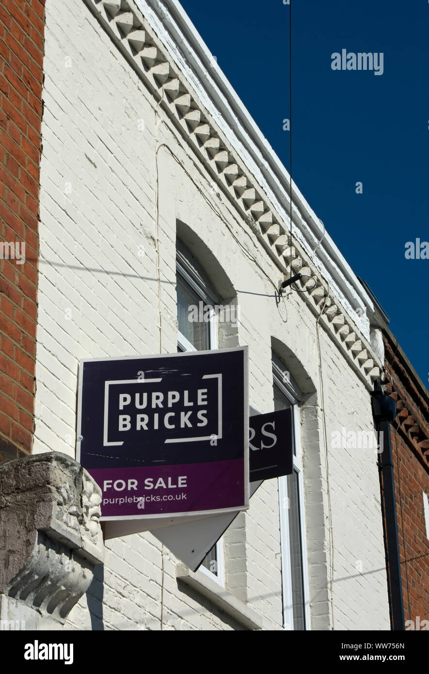 In vendita segno dell'agente immobiliare viola mattoni su un edificio del XIX secolo a Twickenham, middlesex, Inghilterra Foto Stock