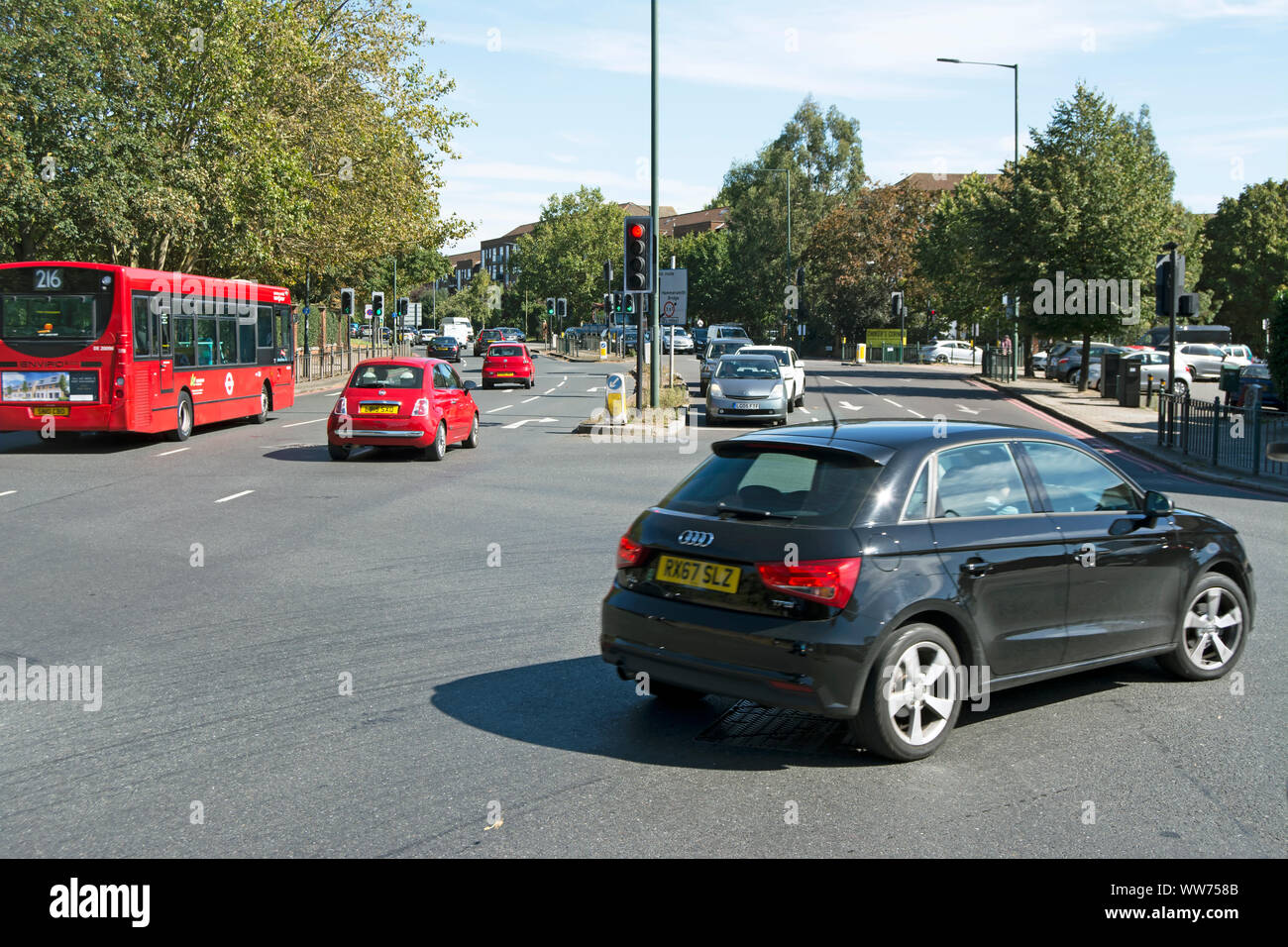 Dei veicoli a motore che attraversano chalkers angolo, una strada trafficata giunzione nel sud-ovest di Londra - Inghilterra Foto Stock