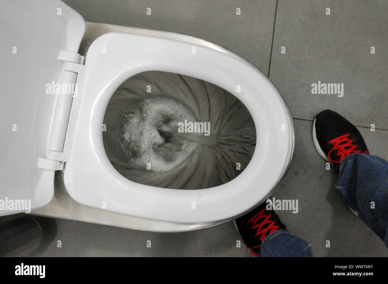 A filo nel WC. Un uomo si risciacqua in bagno. Igiene Foto Stock