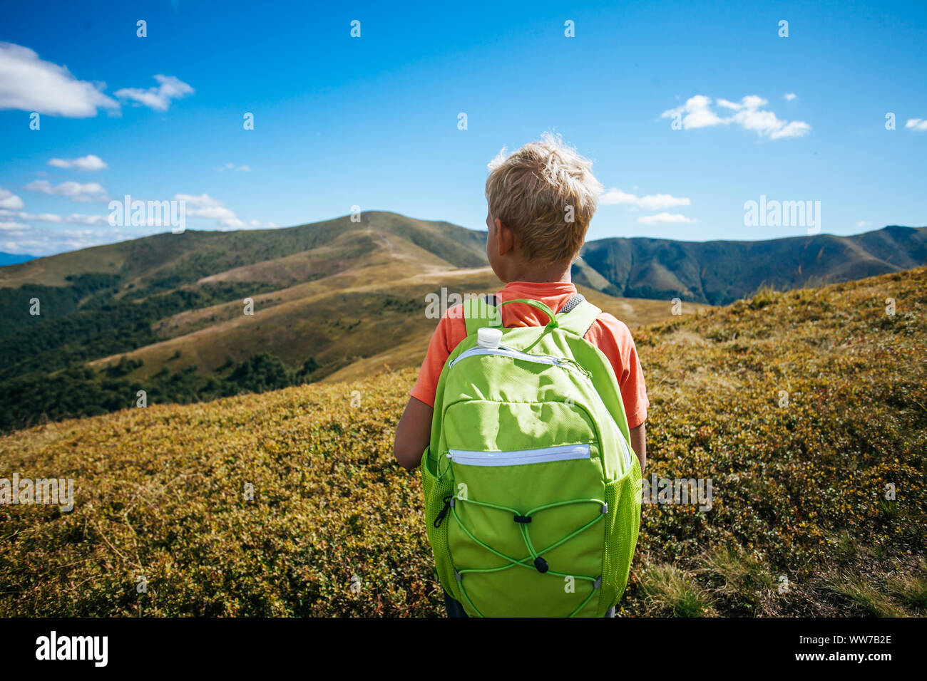 Little Boy con zaino in piedi sulla cima della montagna Foto Stock
