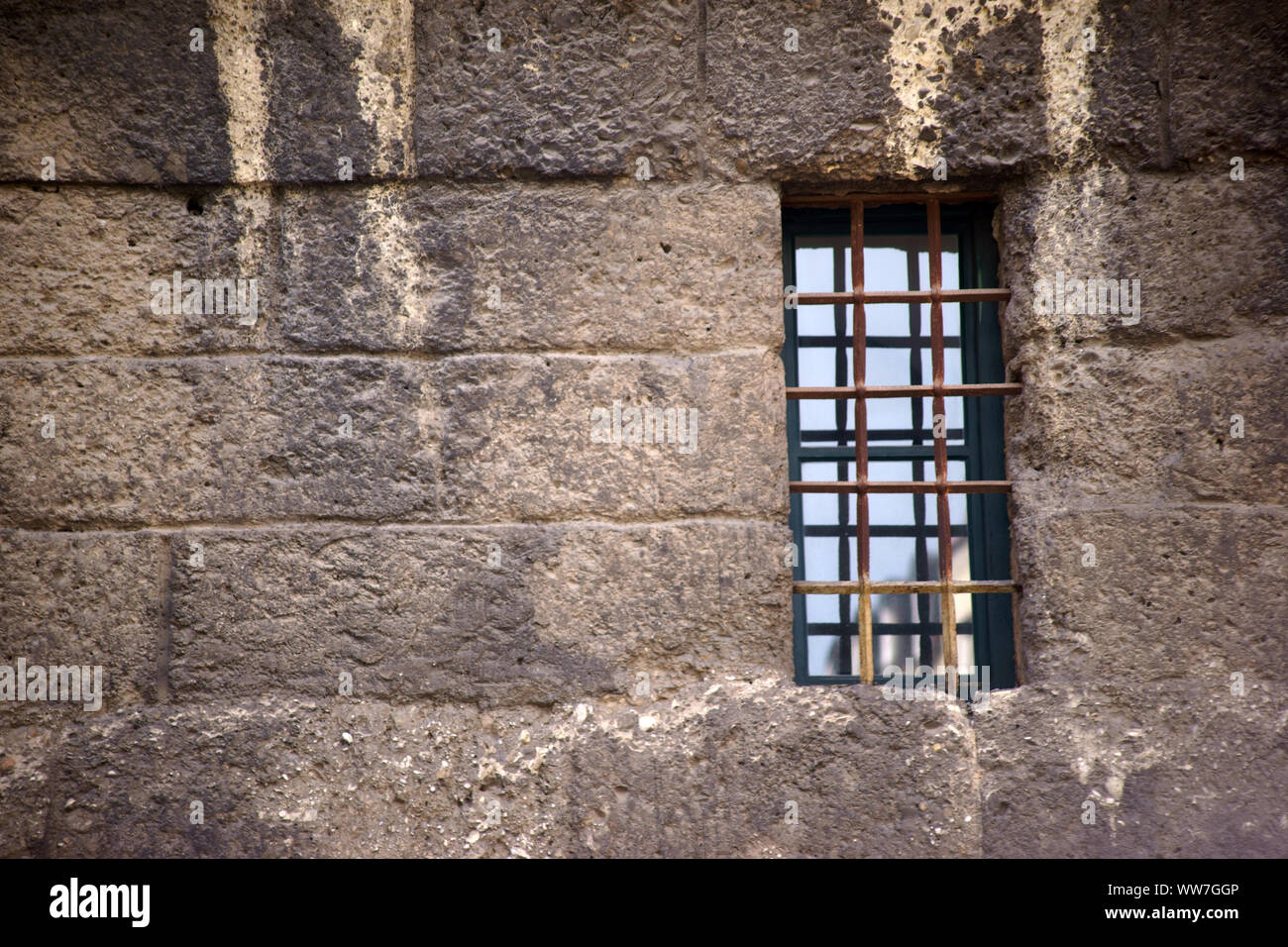 La finestra di nostalgico di una vecchia struttura in muratura con a prova di fuga barre di ferro come reticolo di finestra, Foto Stock