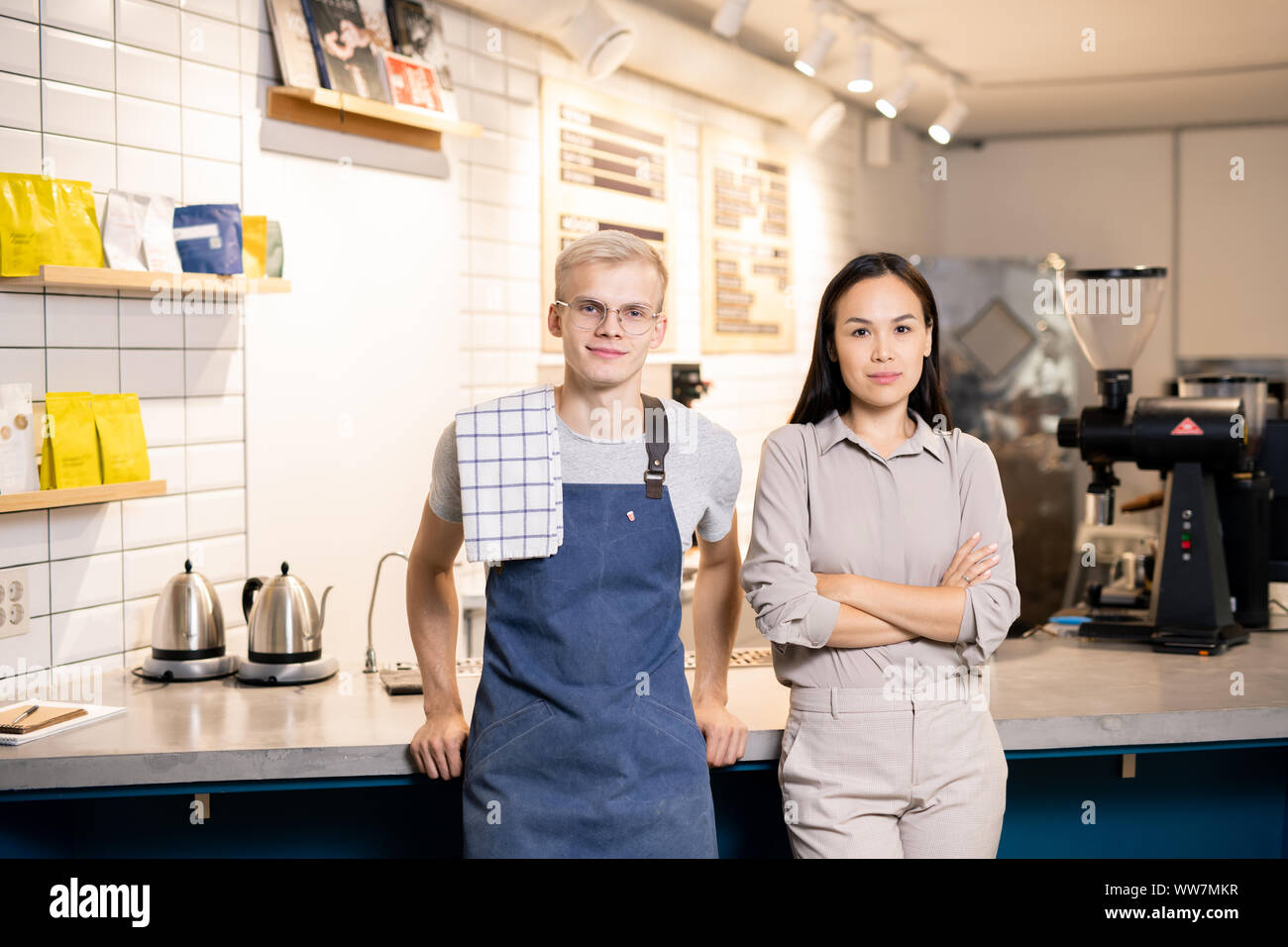 Due giovani lavoratori di contemporaneo bar o un ristorante in piedi dal luogo di lavoro Foto Stock