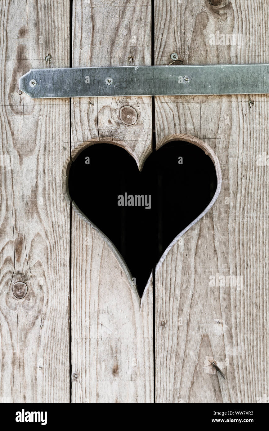 Un taglio cuore in una porta di legno, Foto Stock