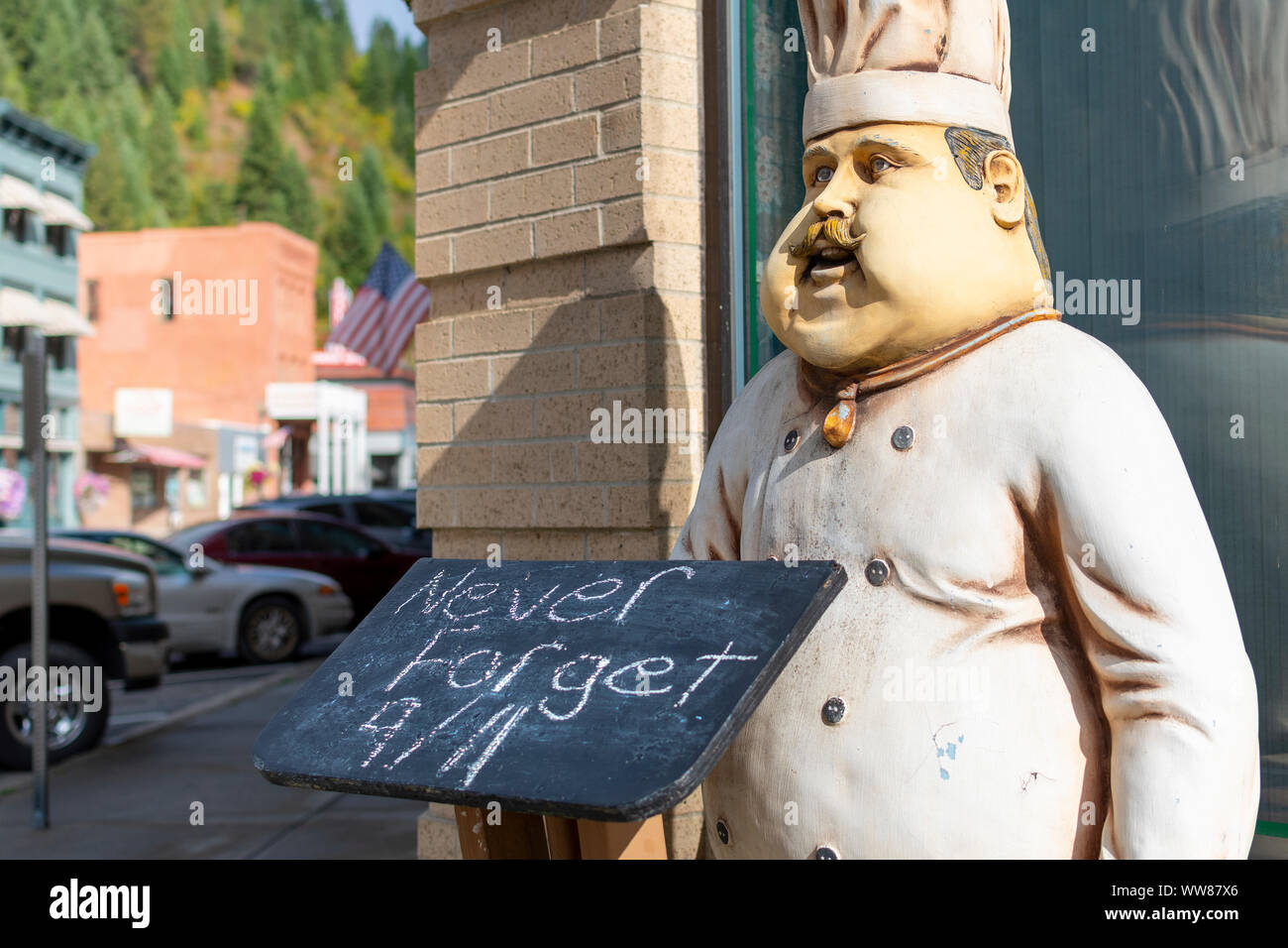 Un cuoco di legno figura con un menu Chalk board con "mai dimenticare 9/11' in onore dell'anniversario del World Trade Center di bombardamenti in Wallace, Idaho. Foto Stock