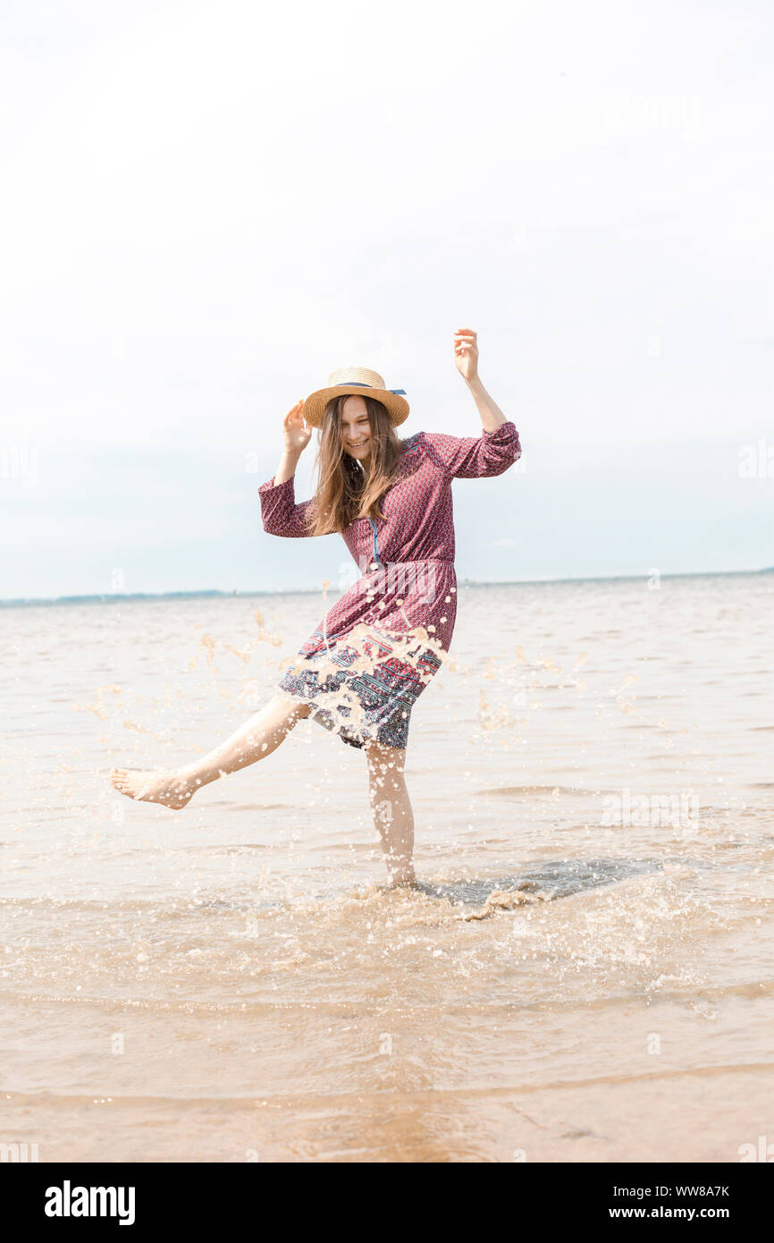 Giovane donna spruzzi di acqua e di energia con i suoi piedi Foto Stock