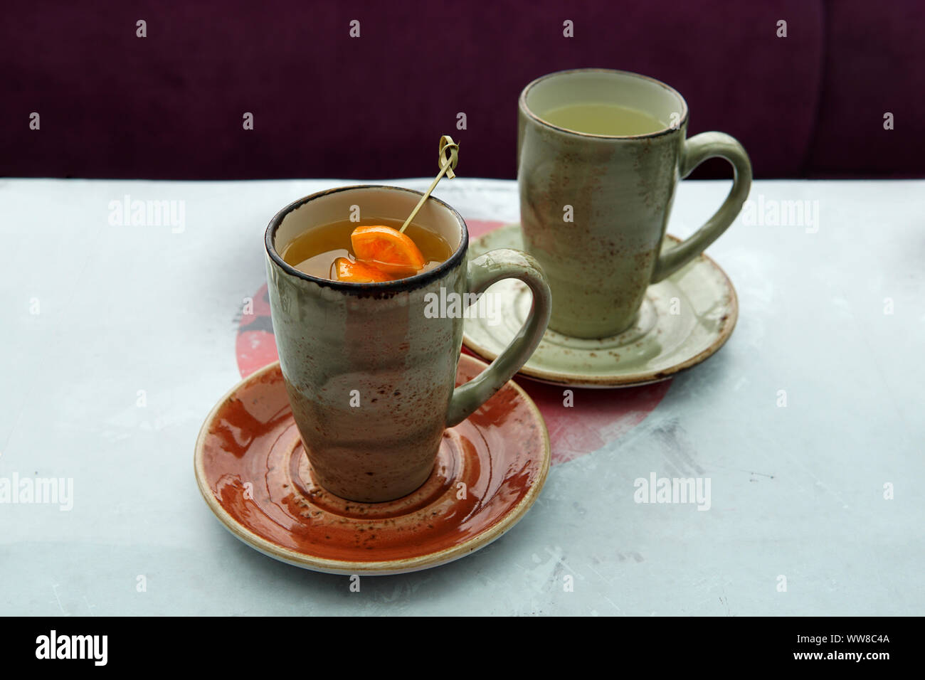 Due tazze di tè: tè di agrumi con mango e fettine di arancia e zenzero tè caldo in un giapponese cafe. Foto Stock