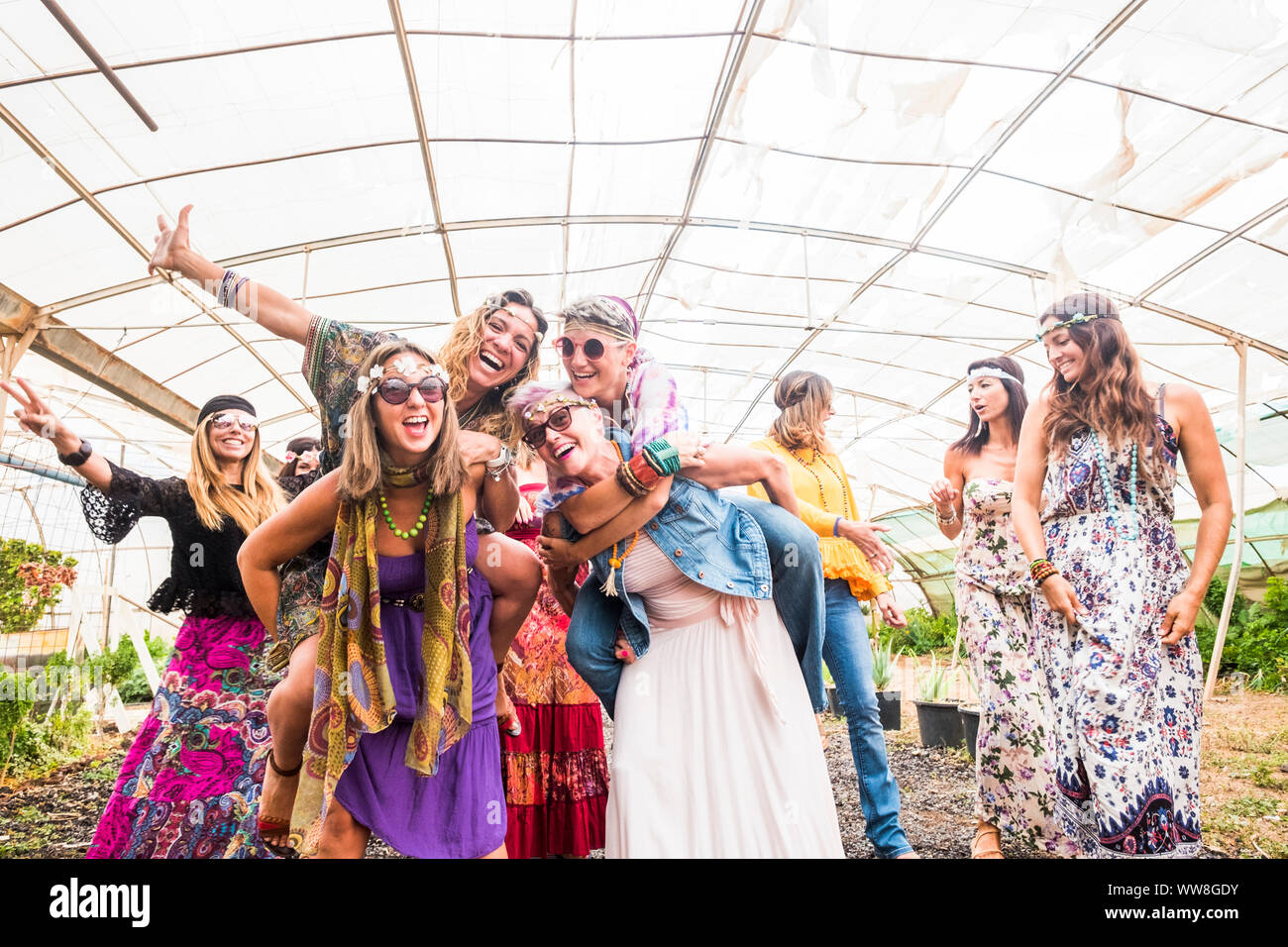 Femmina di persone che ballano insieme in un festival con i tradizionali abiti colorati e vestiti hippy, libertà e alternativa per coloro che godono le attività per il tempo libero, allegro le donne di tutte le età Foto Stock