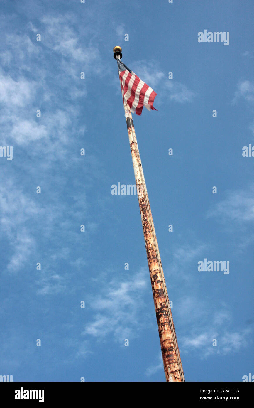 Vecchio danneggiato bandiera degli Stati Uniti sul palo arrugginito Foto Stock