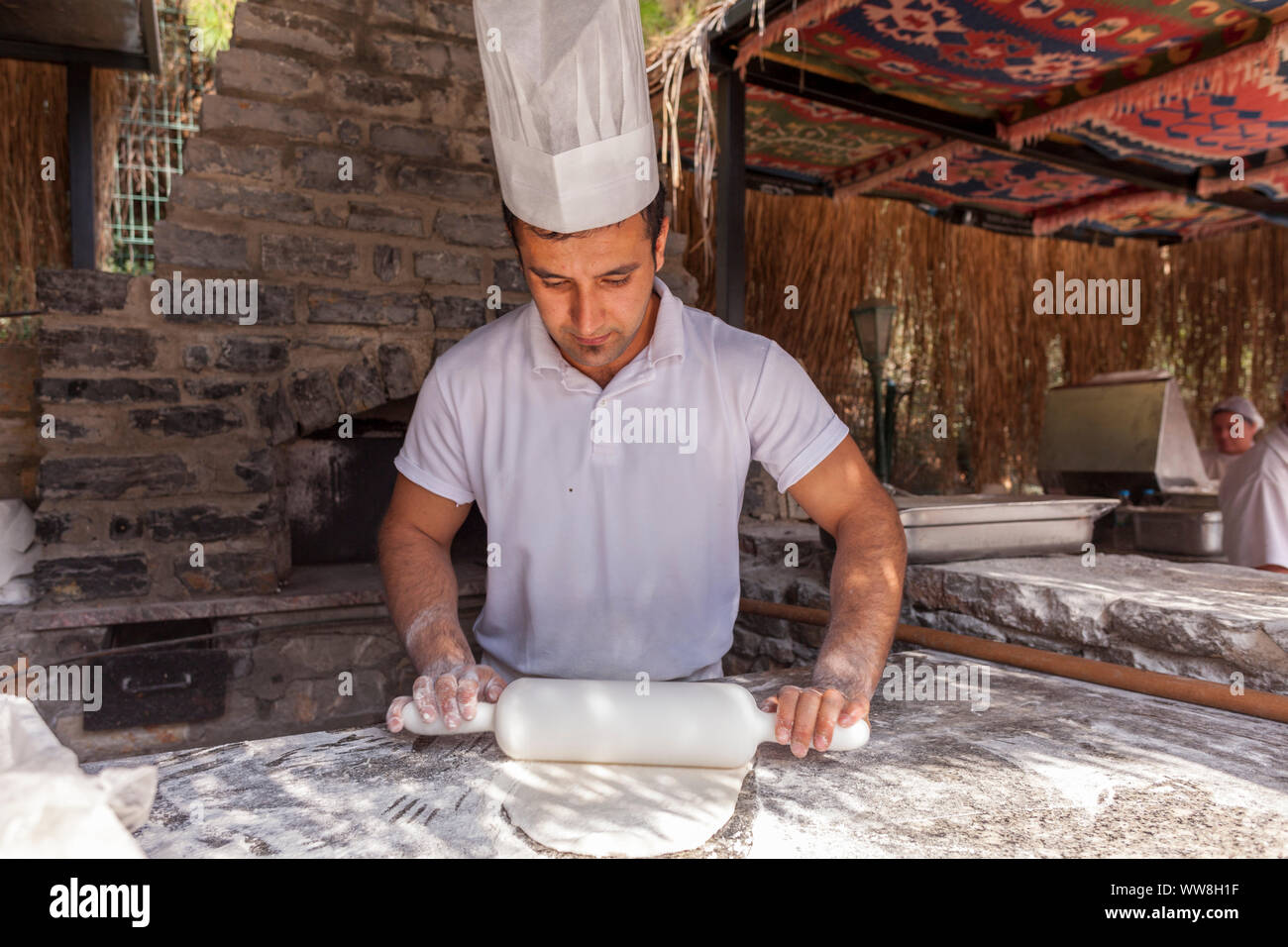 Bagno turco pide baker lievito pide per turisti in una cucina esterna in Spiaggia, Vicino Bodrum, Riviera Turca, Turchia, Eurasia, Foto Stock