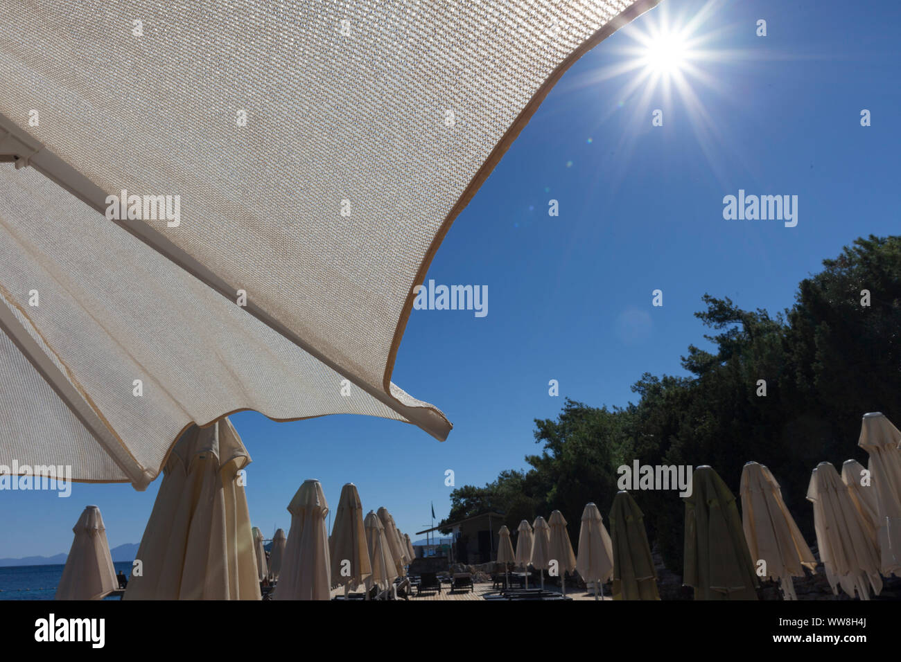 Ombrelloni e sdraio in spiaggia con nessuno, bassa stagione al mattino, a sud di Bodrum, Turchia, Foto Stock