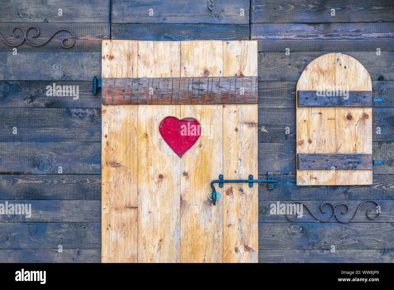 Rustici di legno porta e finestra con il cuore e con decorazioni in ferro, chiuso con chiusura a scatto Foto Stock