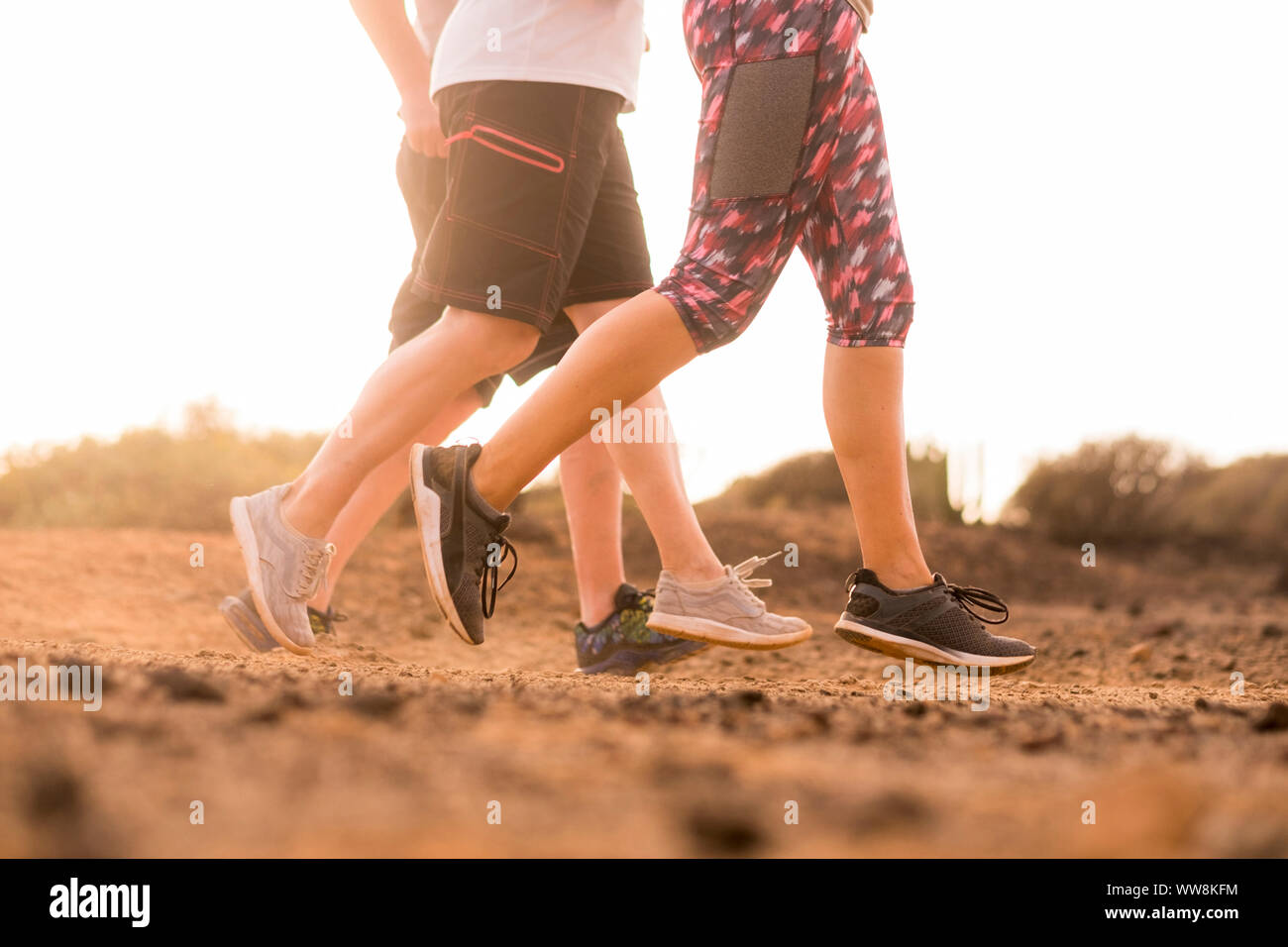 Gruppo di tre caucasian runner facendo jogging sul deserto di Terra Natura outdoor attività. sport e stile di vita sano per le persone. estate meteo giornata di sole Foto Stock