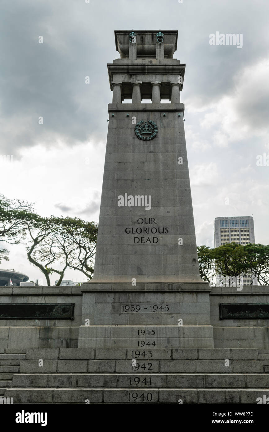 Singapore - Marzo 20, 2019: Ritratto closeup. Grigio pietra il Cenotafio War Memorial circondato dal verde delle foglie nel parco Esplanade sotto pesante cielo grigio prom Foto Stock