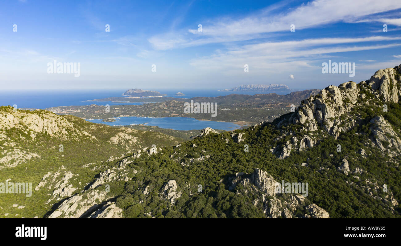 Vista da sopra, vista panoramica di alcune stupende montagne di granito illuminata dal tramonto. Bella Baia con mare turchese in background. Foto Stock