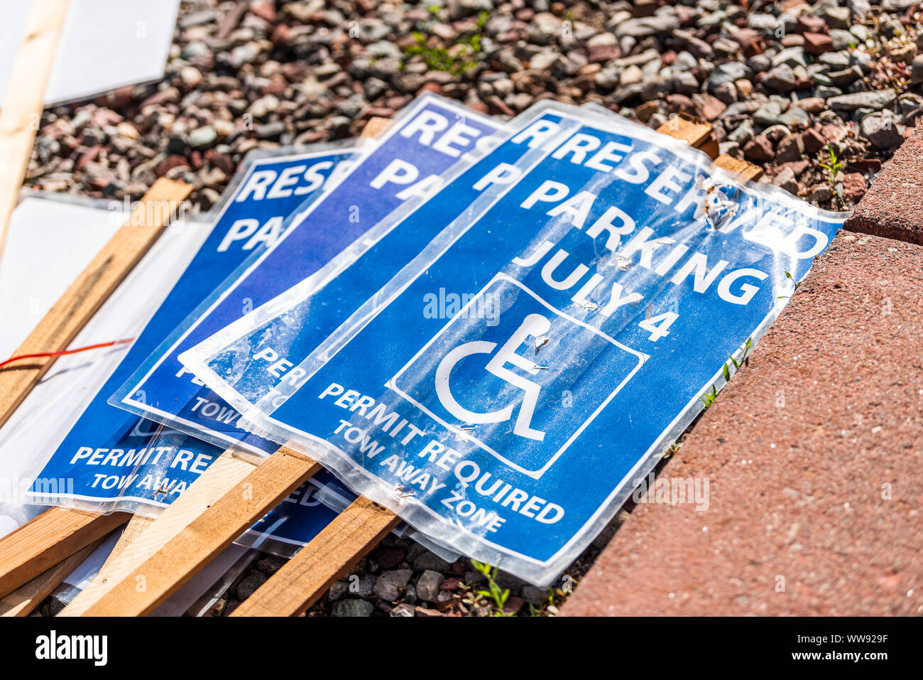 La segnaletica a terra per il 4 luglio il giorno di indipendenza disabili parcheggi con simbolo blu e firmare per il parcheggio riservato è richiesto il permesso di trainare la zona Foto Stock