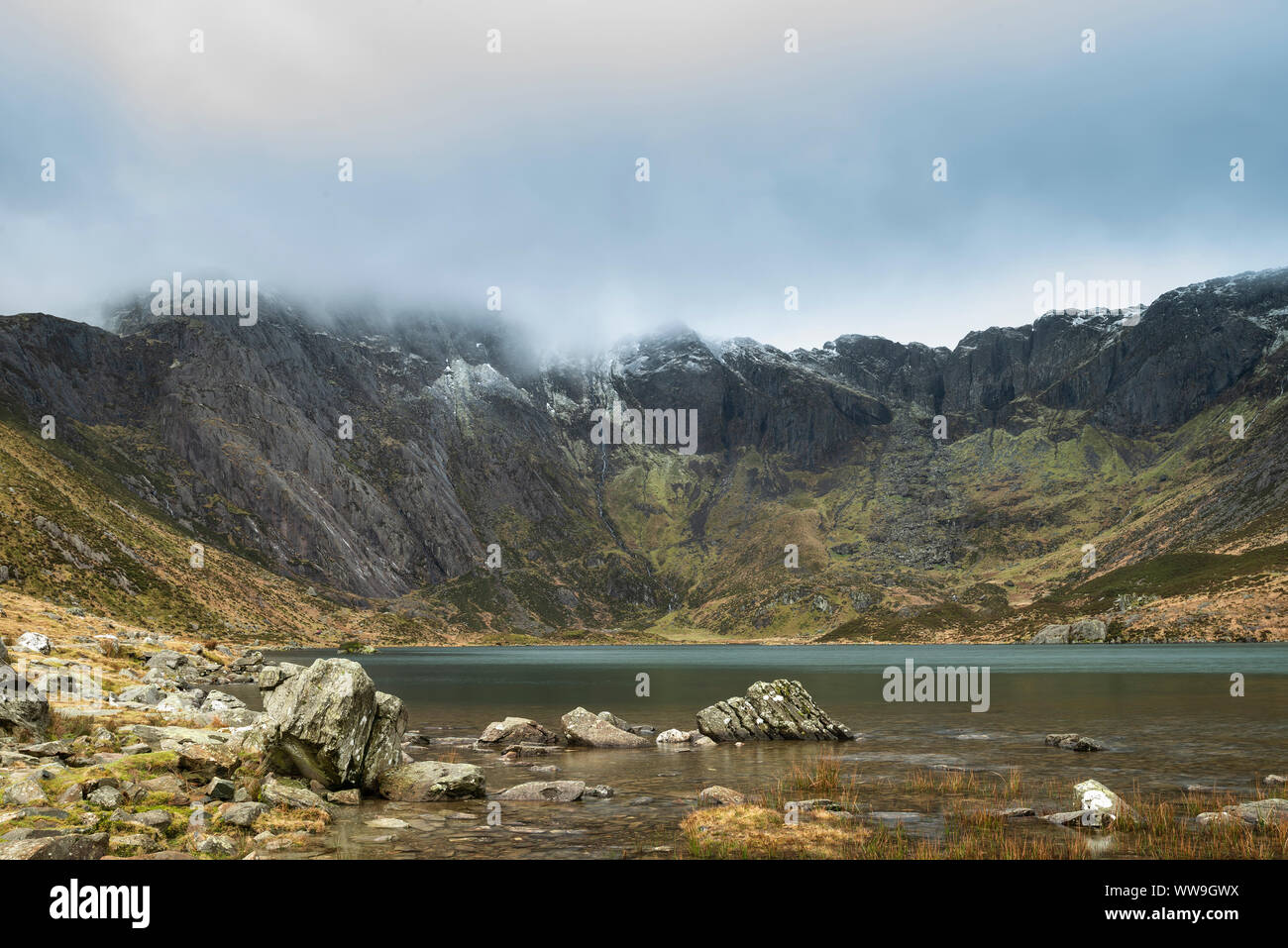 Incredibile drammatico paesaggio invernale immagine del Llyn Idwal e nevato Glyders Mountain Range in Snowdonia Foto Stock