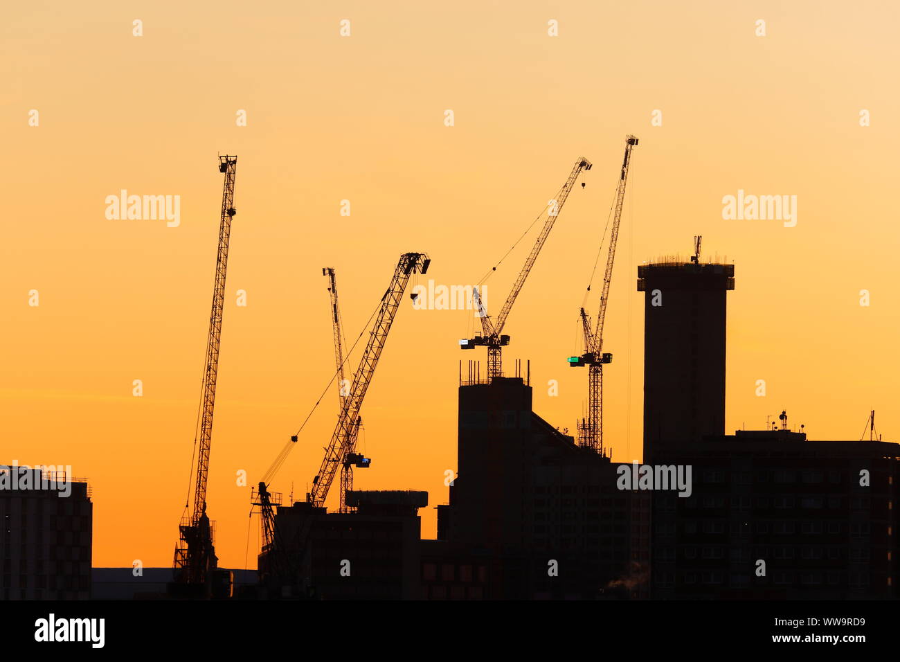 Silhouette di Leeds skyline durante il sunrise. Yorkshire il nuovissimo edificio più alto "Altus House' è in costruzione tra gli altri edifici di nuova costruzione. Foto Stock