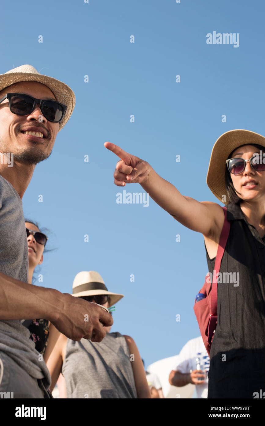 Santorini, Grecia - 24 Giugno 2018: Turisti in cappelli di paglia e occhiali da sole sono incorniciate contro il blu del cielo di mezzogiorno di Oia, una meta turistica molto destinatio Foto Stock