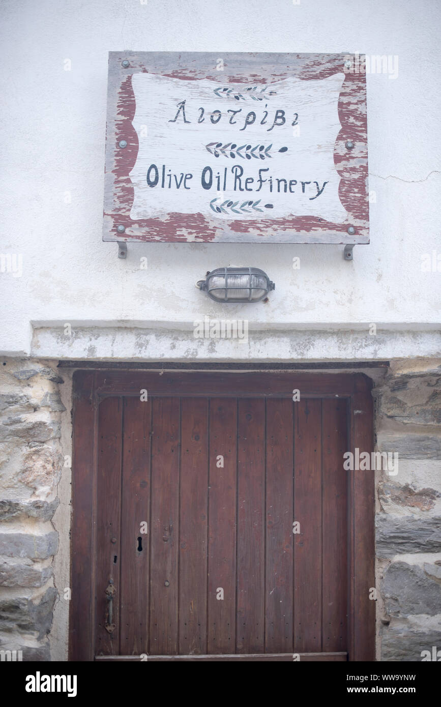 Naxos, Grecia - 28 Giugno 2018: Un antico segno per un olio di oliva raffineria in una giornata di sole in Koronos, un piccolo villaggio sull'isola greca di Naxos. Foto Stock