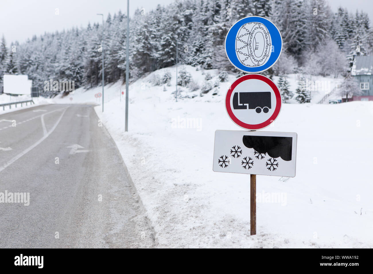 Un cartello stradale avverte circa la necessità di utilizzare le catene da neve e che vietano il movimento di camion con rimorchio nella neve Foto Stock
