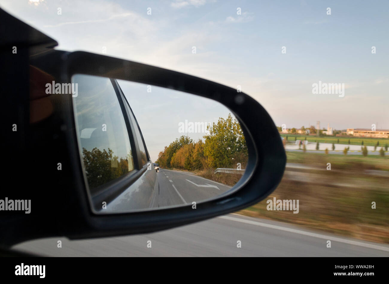 Guardando in specchietto retrovisore laterale durante gli ingorghi di traffico Foto Stock