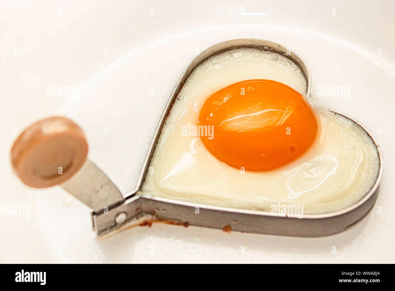 Uova fritte forma di cuore per deliziosi sana colazione semplice su una padella. Foto Stock