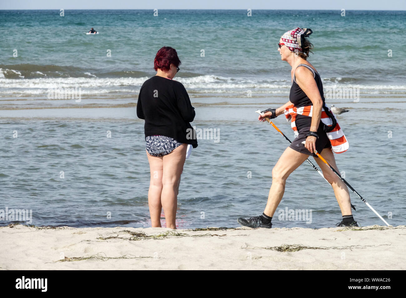 Senior donna anziana nordic walking lungo la spiaggia del Mar Baltico Germania Foto Stock