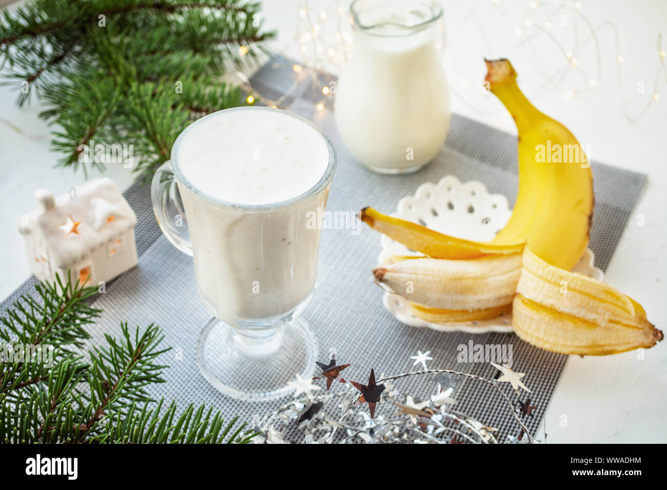 Tradizionale irlandese inverno crema zabaione cocktail in una tazza di vetro con il latte, il rum e la cannella, banana ricoperta con panna montata, le decorazioni di Natale. N Foto Stock