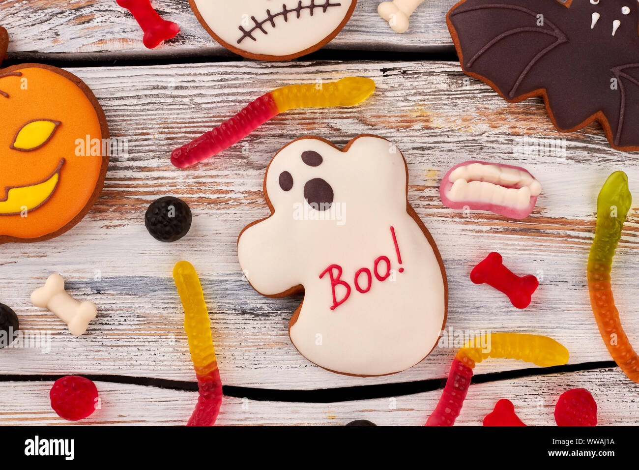 I cookie di Halloween e caramelle su sfondo di legno. Foto Stock