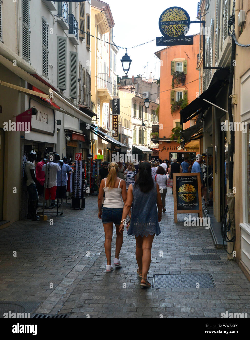 Due giovani ragazze a piedi attraverso le strette strade dello shopping di Rue Meynadier nella città vecchia di Cannes, Cote d'Azur, in Francia, UE. Foto Stock