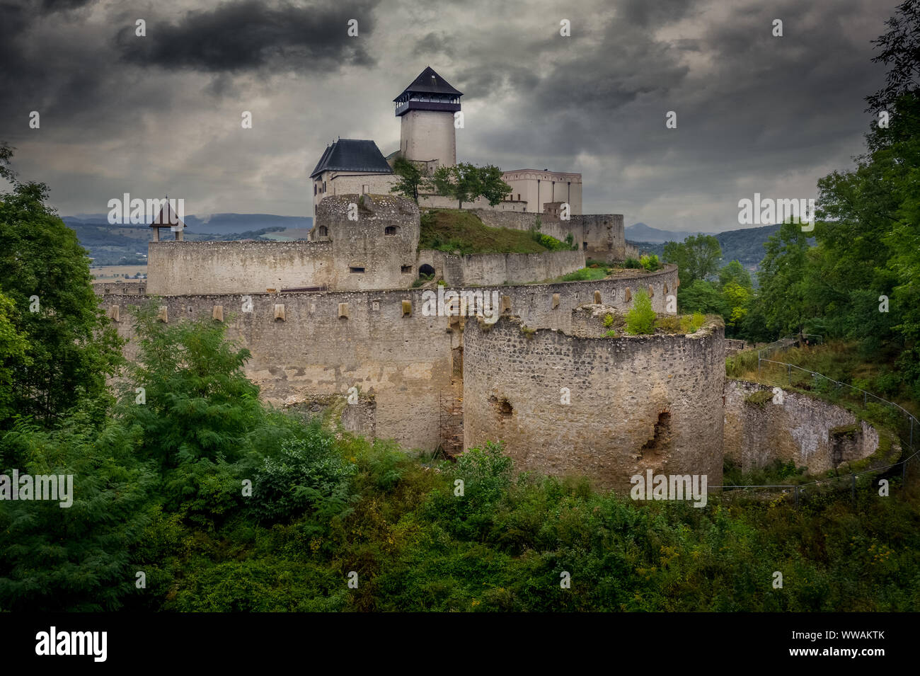 Vista aerea dell'esterno le fortificazioni del castello di Trencin con torre di porta e barbican in Slovacchia drammatico sky Foto Stock