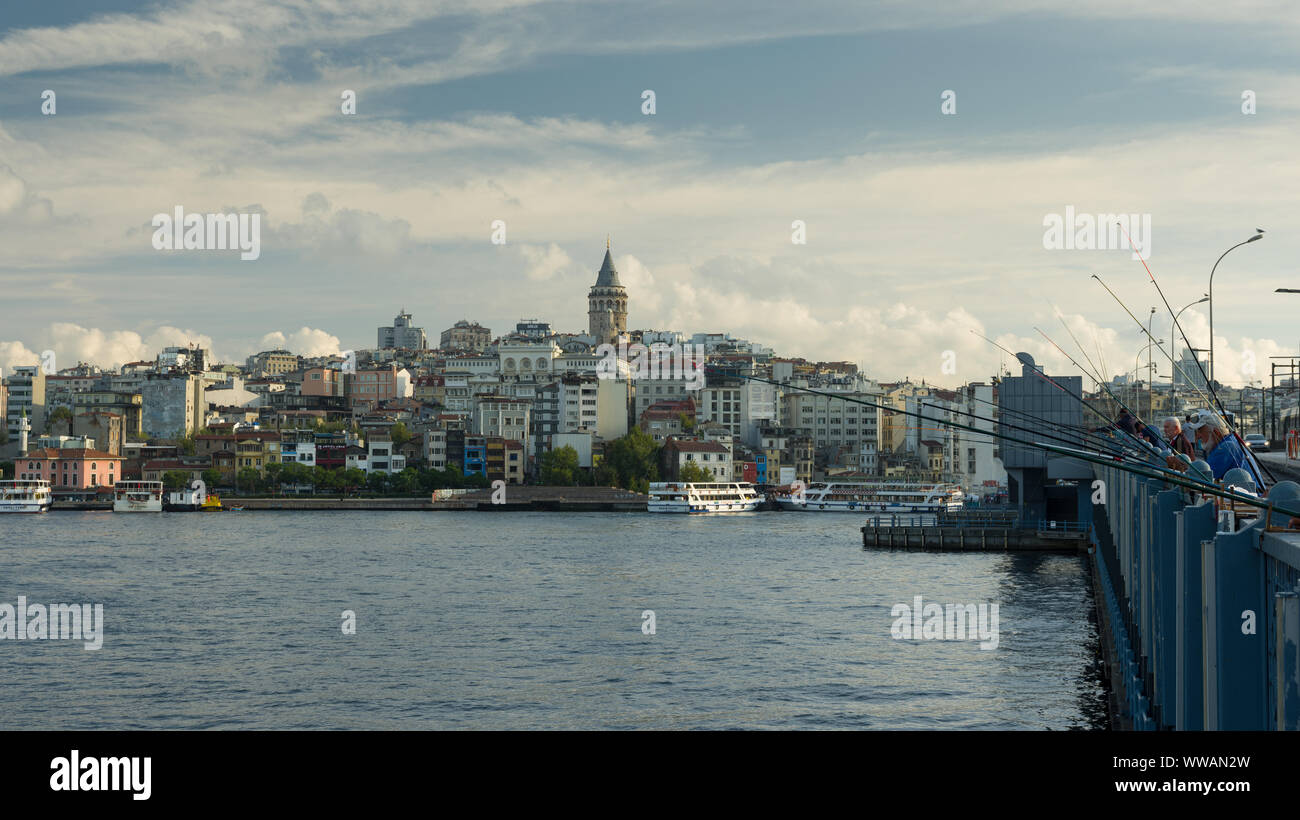 BEYOGLU, ISTANBUL, Turchia - SETTEMBRE, 12, 2019; i pescatori sul Ponte di Galata. Vista della Torre di Galata. Haliç Bay ingresso Foto Stock