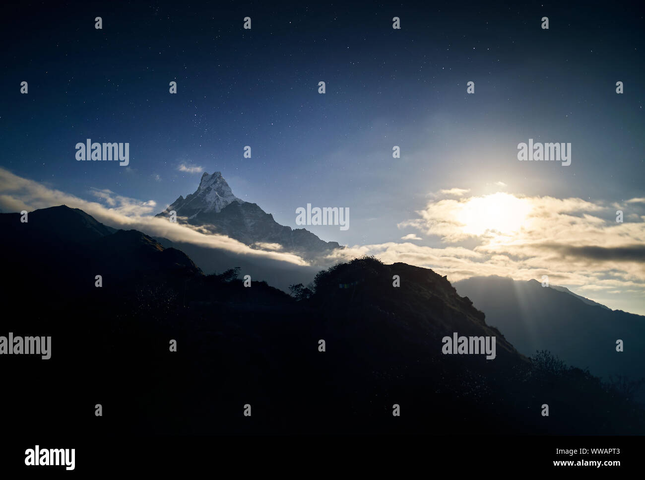 Snowy Machapuchare racconto di pesce mountain durante la notte cielo stellato nel santuario di Annapurna del Nepal Foto Stock