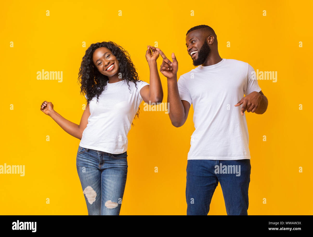 Giovane africano coppia danzante su sfondo giallo Foto Stock