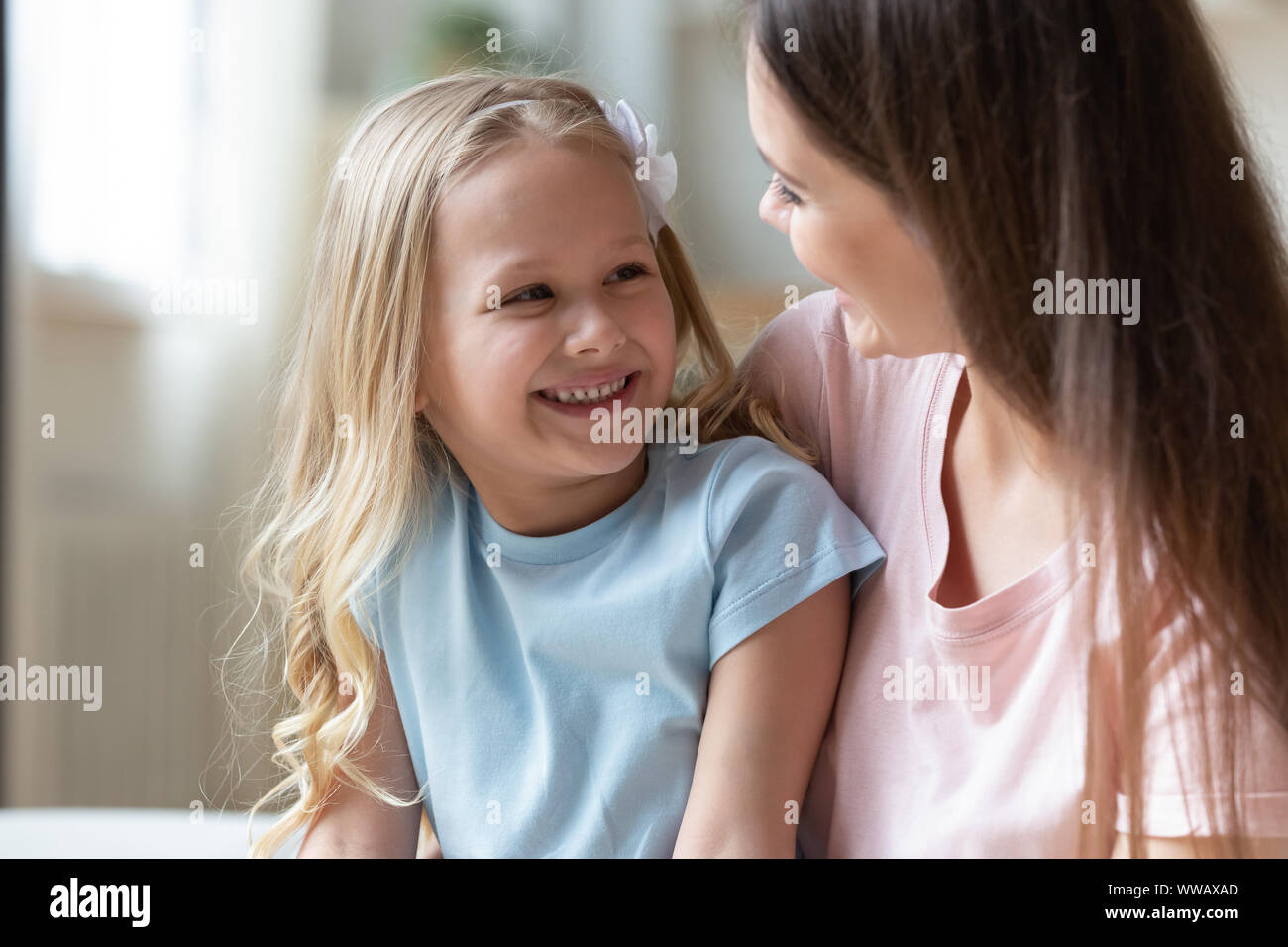 Felice adorabili poco ragazza in età prescolare parlando con positivi mamma. Foto Stock