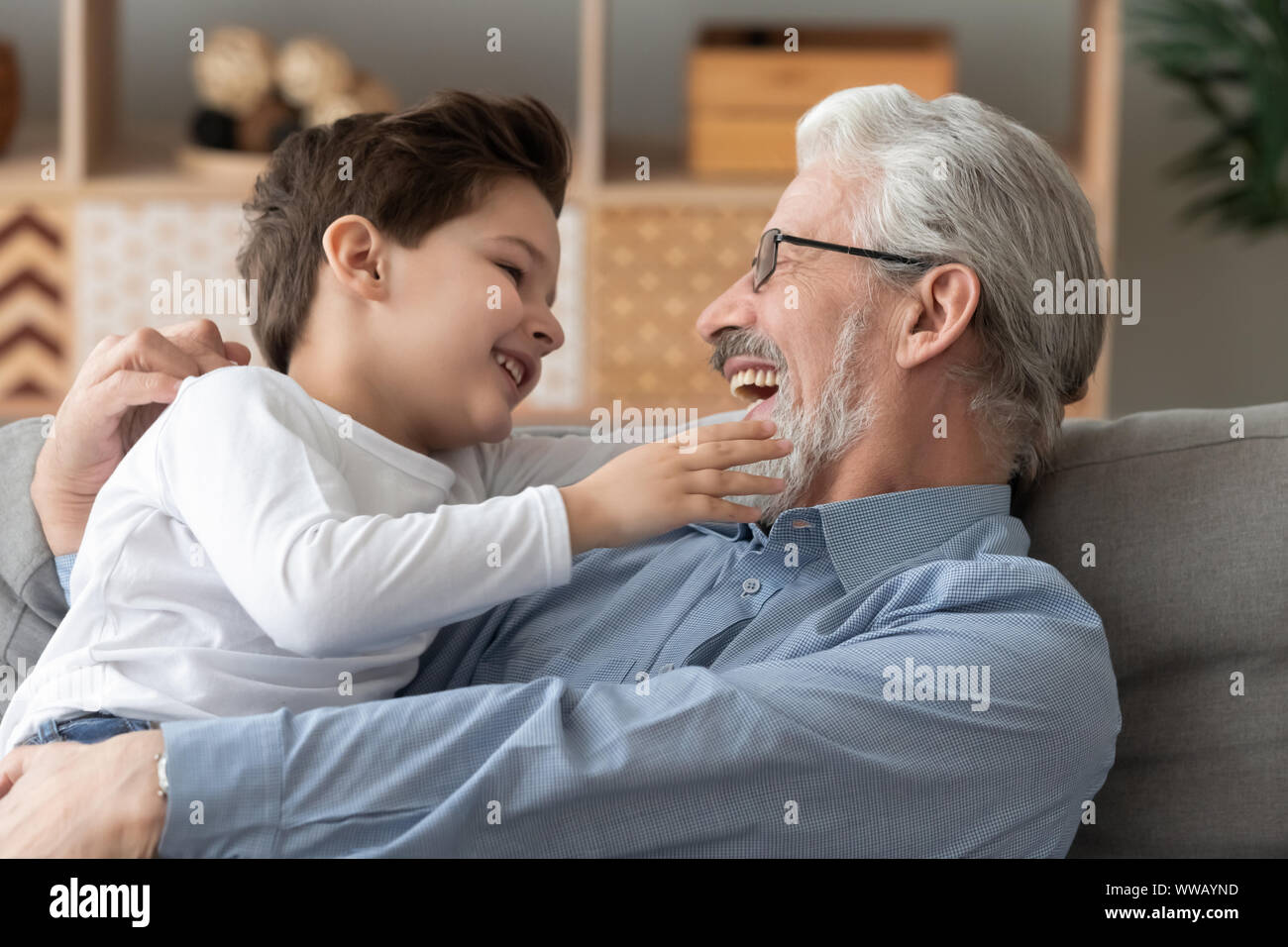 Carino il nipote giocando a ridere il legame con nonno sorridente a casa Foto Stock