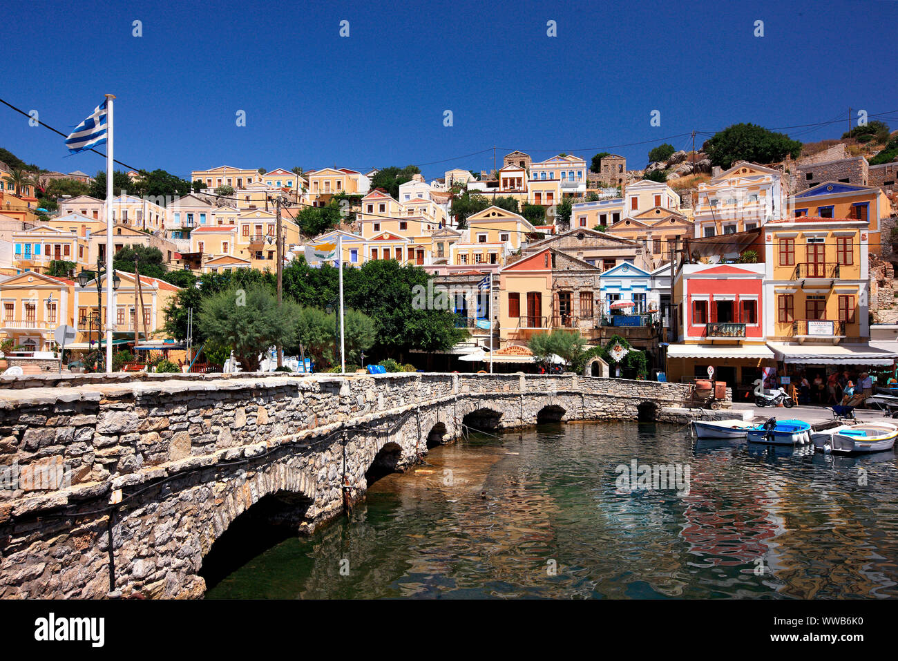 Il ponte di pietra presso il porto di Symi island, Dodecaneso, Mar Egeo, Grecia. Foto Stock