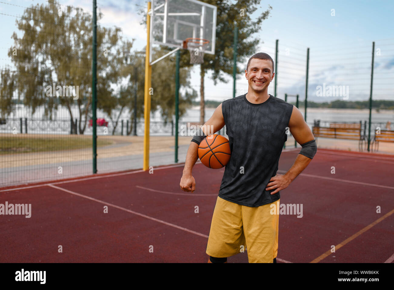Muscolare di giocatore di basket sulla corte esterna Foto Stock